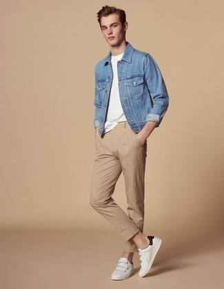 Как носить белые низкие кеды с синей джинсовой курткой мужчине: Образ из синей джинсовой куртки и светло-коричневых брюк чинос поможет создать необыденный мужской лук в стиле кэжуал. Создать модный контраст с остальными вещами из этого ансамбля помогут белые низкие кеды.
