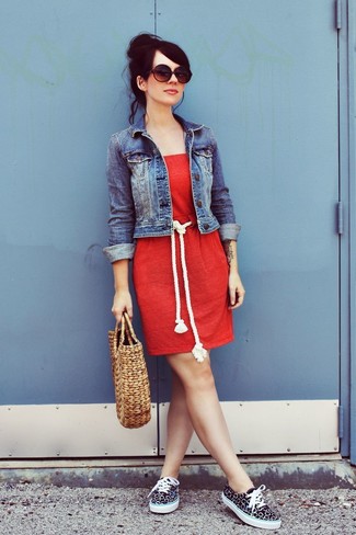 Модный лук: синяя джинсовая куртка, красное повседневное платье, черно-белые низкие кеды из плотной ткани, светло-коричневая соломенная большая сумка