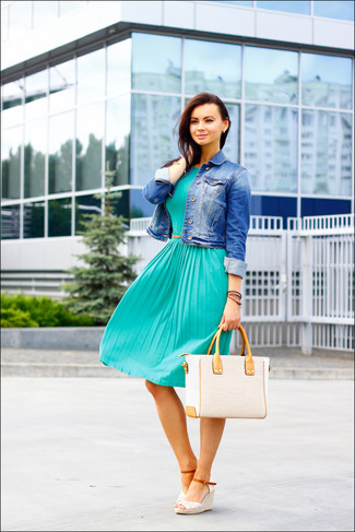 Модный лук: синяя джинсовая куртка, темно-бирюзовое платье-миди со складками, белые босоножки на танкетке крючком, бежевая соломенная большая сумка