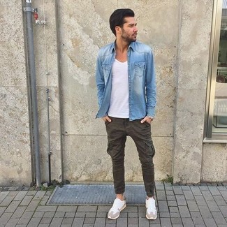 С чем носить синюю джинсовую рубашку мужчине: Примерь сочетание синей джинсовой рубашки и оливковых брюк карго, и ты получишь стильный расслабленный мужской лук для повседневной носки. Если подобный образ кажется слишком дерзким, уравновесь его белыми кроссовками.