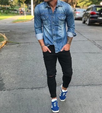 Как носить синюю джинсовую рубашку с черными рваными зауженными джинсами в 20 лет мужчине в теплую погоду: Синяя джинсовая рубашка и черные рваные зауженные джинсы — отличная формула для создания приятного и незамысловатого образа. Сбалансировать лук и добавить в него чуточку классики помогут синие замшевые низкие кеды.