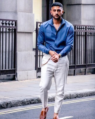 С чем носить коричневые кожаные лоферы в 30 лет мужчине: Синяя классическая рубашка выглядит гармонично в тандеме с белыми классическими брюками. Ты сможешь легко приспособить такой лук к повседневным реалиям, надев коричневыми кожаными лоферами.