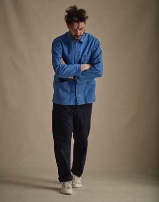 Модный лук: синяя куртка-рубашка, черные брюки чинос, бежевые низкие кеды из плотной ткани, черные кожаные часы