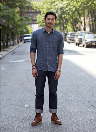 Как носить джинсы с рабочими ботинками мужчине в теплую погоду: Синяя рубашка с длинным рукавом из шамбре и джинсы будет отличной идеей для непринужденного повседневного лука. Любишь поэкспериментировать? Тогда дополни ансамбль рабочими ботинками.