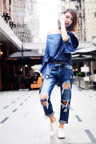С чем носить синие рваные джинсы-бойфренды: Если ты любишь одеваться по моде и при этом чувствовать себя комфортно и нескованно, тебе стоит примерить это сочетание синей джинсовой футболки с круглым вырезом и синих рваных джинсов-бойфрендов. Любишь яркие идеи? Дополни образ белыми низкими кедами.