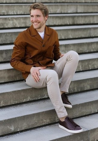 Какие брюки чинос носить с темно-коричневыми низкими кедами в 20 лет в теплую погоду в стиле кэжуал: Табачная куртка-рубашка и брюки чинос — великолепный выбор для офисного ансамбля на каждый день. Создать интересный контраст с остальными предметами из этого образа помогут темно-коричневые низкие кеды.