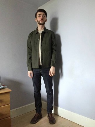 С чем носить оливковую куртку-рубашку в 20 лет мужчине: Если ты любишь смотреться стильно, и при этом чувствовать себя комфортно и нескованно, примерь на себя это сочетание оливковой куртки-рубашки и темно-синих джинсов. Темно-коричневые кожаные ботинки дезерты неплохо дополнят этот образ.