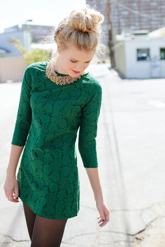 Модный лук: темно-зеленое кружевное платье прямого кроя, золотое колье из бисера, черные колготки