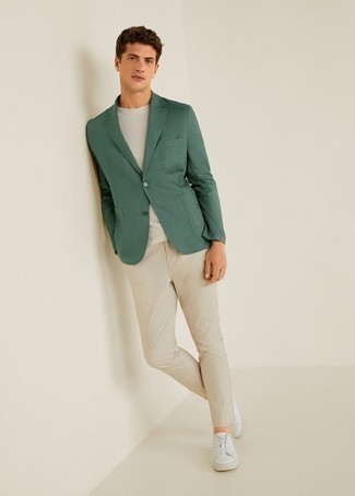 С чем носить темно-зеленый пиджак мужчине в стиле кэжуал: Темно-зеленый пиджак в сочетании с бежевыми брюками чинос позволит подчеркнуть твою индивидуальность и выигрышно выделиться из серой массы. Этот лук чудесно завершат белые кожаные низкие кеды.