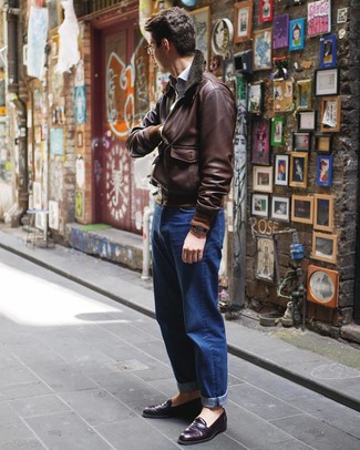 С чем носить коричневый кожаный бомбер мужчине в стиле смарт-кэжуал: Несмотря на свою простоту, образ из коричневого кожаного бомбера и синих джинсов неизменно нравится джентльменам, а также покоряет сердца прекрасных дам. Почему бы не привнести в повседневный образ чуточку нарядности с помощью темно-пурпурных кожаных лоферов?