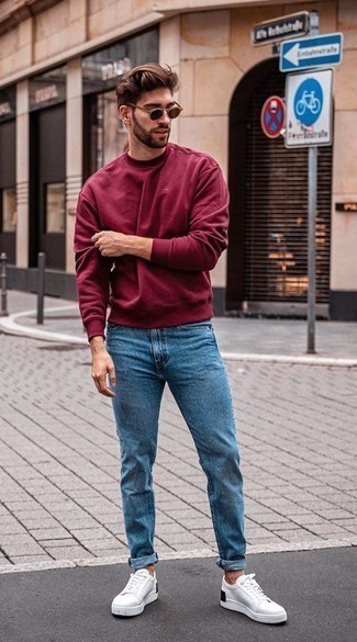 Как носить синие джинсы с бело-черными низкими кедами из плотной ткани в 30 лет мужчине в теплую погоду в стиле кэжуал: Темно-красный свитшот и синие джинсы — превосходная идея для простого, но стильного мужского образа. Что до обуви, можно завершить образ бело-черными низкими кедами из плотной ткани.