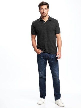 Модный лук: темно-серая футболка-поло, темно-синие джинсы, белые кожаные низкие кеды