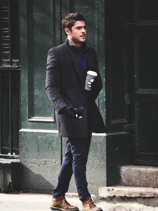 Как носить коричневые замшевые ботинки дезерты с темно-серым длинным пальто в стиле смарт-кэжуал: Если ты приписываешь себя к той редкой категории парней, ориентирующихся в трендах, тебе подойдет образ из темно-серого длинного пальто и темно-синих брюк чинос. Ты можешь легко приспособить такой ансамбль к повседневным условиям городской жизни, надев коричневыми замшевыми ботинками дезертами.