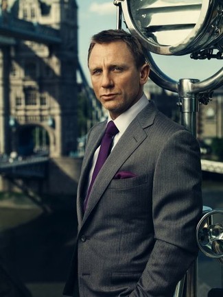 С чем носить пурпурный галстук за 40 лет мужчине в стиле смарт-кэжуал: Темно-серый пиджак в вертикальную полоску и пурпурный галстук — образец элегантного мужского стиля в одежде.