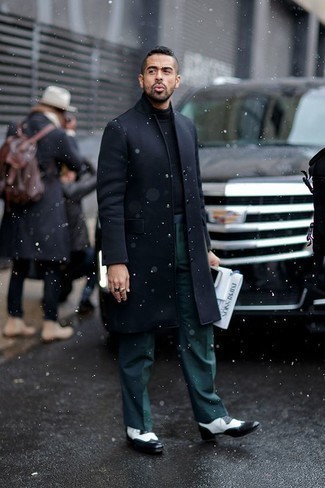 Какие длинные пальто носить с темно-зелеными классическими брюками в теплую погоду в деловом стиле: Длинное пальто в сочетании с темно-зелеными классическими брюками позволит составить стильный и привлекательный лук. Ну и почему бы не разбавить лук с помощью черно-белых кожаных брогов?