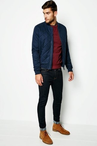 Модный лук: темно-синий стеганый бомбер, темно-красный свитер с круглым вырезом, черные зауженные джинсы, светло-коричневые замшевые ботинки дезерты