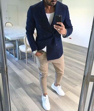 С чем носить синий двубортный пиджак мужчине лето в стиле смарт-кэжуал: Синий двубортный пиджак и бежевые зауженные джинсы — великолепный вариант для повседневного офисного лука. Поклонники смелых сочетаний могут дополнить лук белыми кожаными низкими кедами. Подобный образ обеспечивает свободу движений в настоящий зной и уверенность в том, что ты выглядишь безукоризненно.