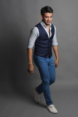 Как носить синие джинсы с белыми низкими кедами из плотной ткани мужчине лето в стиле смарт-кэжуал: Ансамбль из темно-синего жилета и синих джинсов смотрится очень привлекательно и элегантно. Создать выразительный контраст с остальными вещами из этого лука помогут белые низкие кеды из плотной ткани. Хорошо помнить о такой одежде, особенно когда термометр начинает показывать более теплую температуру.