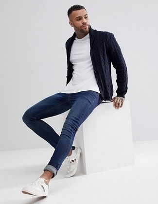 С чем носить темно-синий кардиган мужчине: Сочетание темно-синего кардигана и темно-синих зауженных джинсов поможет реализовать в твоем образе городской стиль современного мужчины. Если говорить об обуви, белые кожаные низкие кеды являются отличным выбором.