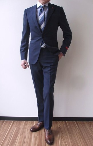 Модный лук: темно-синий костюм в вертикальную полоску, белая классическая рубашка, коричневые кожаные оксфорды, синий галстук в горизонтальную полоску
