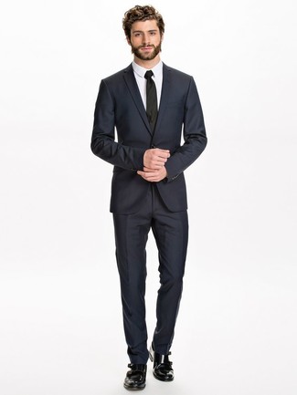 С чем носить черные кожаные монки в 30 лет: Темно-синий костюм и белая классическая рубашка помогут составить эффектный мужской образ. Этот образ органично дополнят черные кожаные монки.