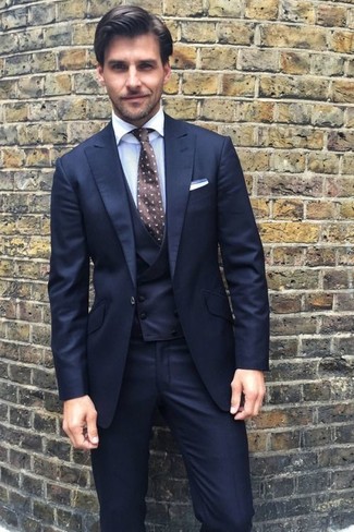 С чем носить табачный галстук в горошек мужчине в теплую погоду: Темно-синий костюм-тройка и табачный галстук в горошек — превосходный пример элегантного мужского стиля.