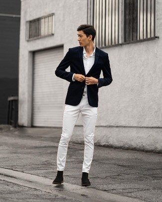С чем носить белые рваные джинсы мужчине в теплую погоду: Темно-синий пиджак и белые рваные джинсы прочно закрепились в гардеробе многих мужчин, позволяя составлять потрясающие и стильные луки. Этот ансамбль легко получает новое прочтение в тандеме с черными замшевыми ботинками челси.