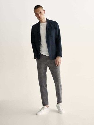 С чем носить темно-синий пиджак в 20 лет мужчине в стиле кэжуал: Надев темно-синий пиджак и серые брюки чинос, можно с уверенностью отправляться на неофициальную встречу или культурное мероприятие. Поклонники смелых вариантов могут дополнить лук белыми низкими кедами из плотной ткани.