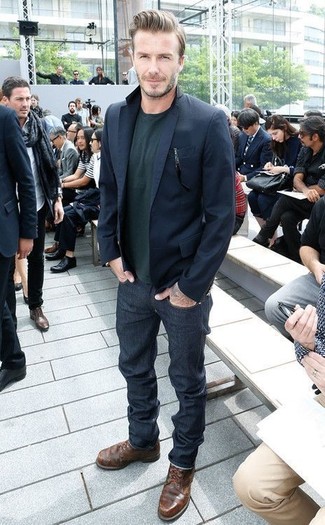 Как David Beckham носит Темно-синий пиджак, Темно-зеленый свитер с круглым вырезом, Темно-синие джинсы, Темно-коричневые кожаные повседневные ботинки