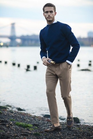 С чем носить темно-синий свитер с круглым вырезом мужчине в стиле смарт-кэжуал: Темно-синий свитер с круглым вырезом и светло-коричневые классические брюки — хороший лук для мероприятия в фешенебельном заведении. Вкупе с этим луком органично будут выглядеть темно-коричневые кожаные лоферы.