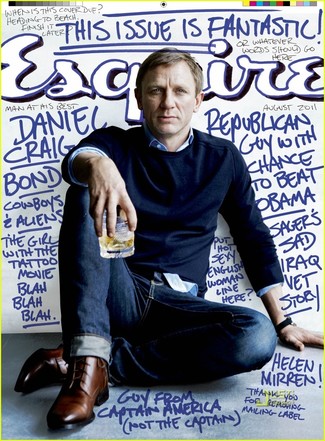 Как Daniel Craig носит Темно-синий свитер с круглым вырезом, Синяя классическая рубашка, Темно-синие джинсы, Коричневые кожаные туфли дерби