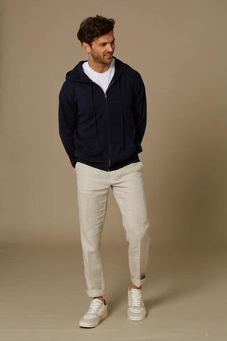 С чем носить бежевые льняные брюки чинос в 30 лет весна в стиле кэжуал: Темно-синий худи в сочетании с бежевыми льняными брюками чинос поможет подчеркнуть твою индивидуальность. Очень подходяще здесь смотрятся белые кожаные низкие кеды. Когда зимний сезон сменяется более теплыми деньками, мы скидываем теплую зимнюю одежду и встает вопрос о том, что носить. Подобное сочетание вещей поможет тебе найти необходимое вдохновение.