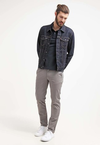 Модный лук: темно-синяя джинсовая куртка, черная футболка-поло, серые брюки чинос, белые низкие кеды
