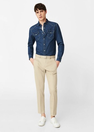С чем носить темно-синюю джинсовую рубашку мужчине в стиле смарт-кэжуал: Любой молодой человек будет выглядеть безупречно в темно-синей джинсовой рубашке и бежевых классических брюках. Если сочетание несочетаемого привлекает тебя не меньше, чем проверенная классика, дополни этот наряд белыми кожаными низкими кедами.