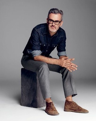 С чем носить синюю джинсовую рубашку за 50 лет мужчине в стиле кэжуал: Сочетание синей джинсовой рубашки и серых брюк чинос продолжает импонировать парням, которые любят одеваться со вкусом. Что касается обуви, коричневые замшевые ботинки дезерты — самый удачный вариант.
