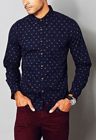 С чем носить темно-синюю рубашку с "огурцами" мужчине: Сочетание темно-синей рубашки с "огурцами" и темно-красных брюк чинос позволит создать стильный, и в то же время мужественный образ.