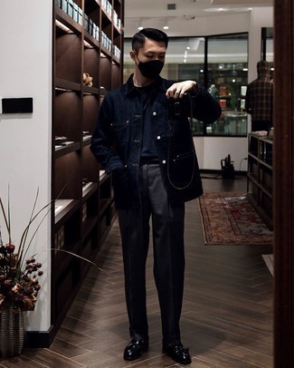 Как носить темно-серые классические брюки с черными кожаными лоферами с кисточками в стиле смарт-кэжуал: Темно-синяя джинсовая куртка-рубашка в паре с темно-серыми классическими брюками позволит создать эффектный мужской лук. Вкупе с этим луком прекрасно смотрятся черные кожаные лоферы с кисточками.