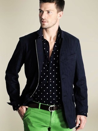 Модный лук: темно-синяя куртка с воротником и на пуговицах, черно-белая рубашка с длинным рукавом в горошек, зеленые брюки чинос, темно-коричневый кожаный ремень