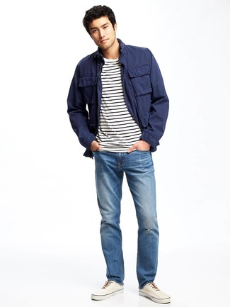 Модный лук: темно-синяя полевая куртка, бело-черная футболка с круглым вырезом в горизонтальную полоску, синие джинсы, белые плимсоллы