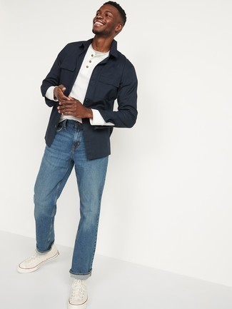 С чем носить темно-синюю рубашку с длинным рукавом в 20 лет мужчине в теплую погоду: Темно-синяя рубашка с длинным рукавом и синие джинсы — неотъемлемые вещи в арсенале мужчин с превосходным чувством стиля. Нравится экспериментировать? Тогда заверши лук белыми высокими кедами из плотной ткани.