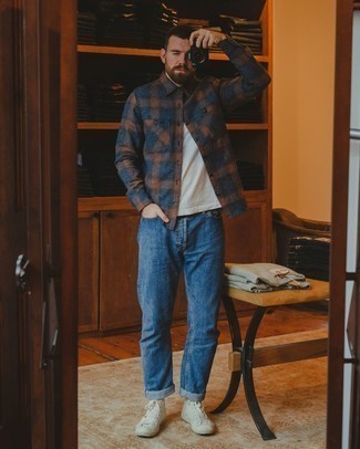 Как носить синие джинсы с бело-красными высокими кедами из плотной ткани мужчине: Дуэт темно-синей фланелевой рубашки с длинным рукавом в шотландскую клетку и синих джинсов смотрится круто и интересно. Такой образ легко приспособить к повседневным делам, если дополнить его бело-красными высокими кедами из плотной ткани.