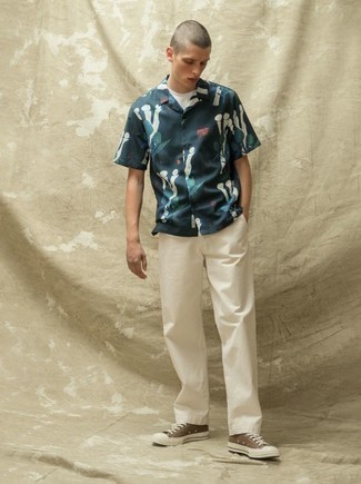 Какие брюки чинос носить с табачными низкими кедами в стиле кэжуал: Сочетание темно-синей рубашки с коротким рукавом с принтом и брюк чинос смотрится привлекательно и стильно. Табачные низкие кеды удачно дополнят этот образ.
