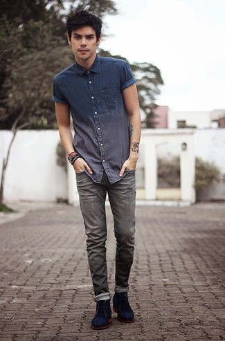 С чем носить темно-серые джинсы в 20 лет мужчине лето в стиле кэжуал: Если в одежде ты ценишь удобство и практичность, обрати внимание на дуэт темно-синей рубашки с коротким рукавом из шамбре и темно-серых джинсов. Хочешь привнести в этот лук нотку элегантности? Тогда в качестве обуви к этому ансамблю, выбери темно-синие замшевые ботинки дезерты. Такой ансамбль может стать твоим спасением, когда за окном больше 25 градусов тепла.