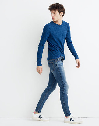 С чем носить темно-синие рваные зауженные джинсы мужчине лето: Если у тебя наметился суматошный день, сочетание темно-синей футболки с длинным рукавом и темно-синих рваных зауженных джинсов поможет составить функциональный образ в непринужденном стиле. Если тебе нравится смешивать в своих образах разные стили, из обуви можешь надеть бело-темно-синие кожаные низкие кеды. Подобное сочетание одежды может стать настоящим спасением, если за окном пекло.