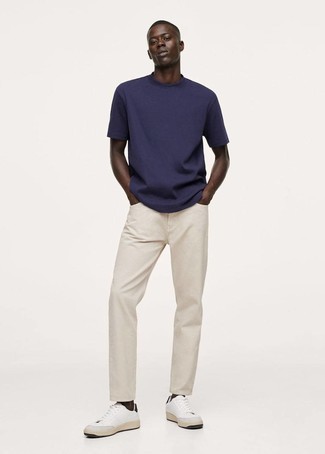 Как носить джинсы с низкими кедами в 20 лет мужчине в стиле кэжуал: Темно-синяя футболка с круглым вырезом и джинсы — идеальный вариант для похода в кино или марафона по городским барам. Если говорить об обуви, низкие кеды являются классным выбором.