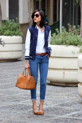 Женские луки в теплую погоду: Дуэт темно-сине-белой университетской куртки и синих джинсов скинни смотрится очень привлекательно, разве нет? В тандеме с этим образом прекрасно будут смотреться коричневые замшевые туфли.