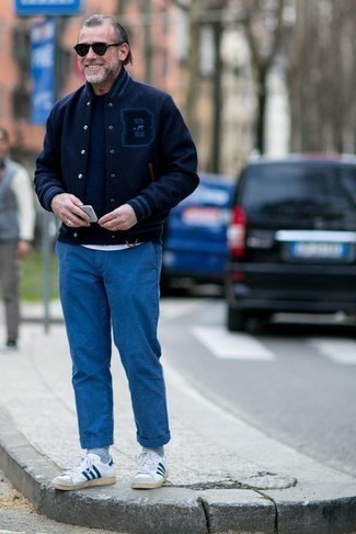 С чем носить синие брюки за 50 лет мужчине весна в стиле кэжуал: Стильное сочетание темно-синей университетской куртки и синих брюк поможет подчеркнуть твою индивидуальность и выгодно выделиться из толпы. Хотел бы сделать лук немного элегантнее? Тогда в качестве дополнения к этому ансамблю, стоит выбрать бело-темно-синие кожаные низкие кеды. Когда зимний сезон уходит и сменяется более теплыми деньками, хочется смотреться стильно, излучать ауру силы и уверенности и заряжать хорошим настроением. Такое сочетание одежды обязательно в этом поможет.