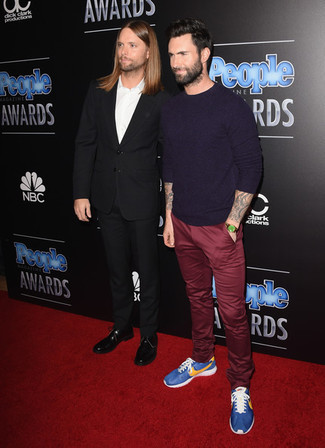 Как Adam Levine носит Фиолетовый свитер с круглым вырезом, Темно-красные брюки чинос, Синие кроссовки