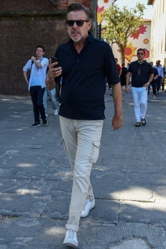 С чем носить оливковые солнцезащитные очки за 40 лет мужчине в жару: Сочетание темно-синей футболки-поло и оливковых солнцезащитных очков - очень практично, и поэтому идеально для воплощения привлекательного повседневного стиля. Думаешь сделать образ немного элегантнее? Тогда в качестве обуви к этому ансамблю, стоит выбрать белые низкие кеды из плотной ткани.