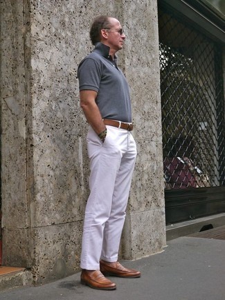 С чем носить коричневые кожаные лоферы за 40 лет мужчине в жару: Стильное сочетание серой футболки-поло и белых брюк чинос однозначно будет привлекать взгляды красивых женщин. Коричневые кожаные лоферы добавят ансамблю утонченности.